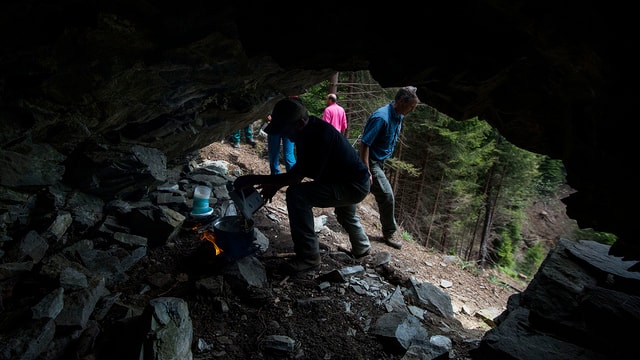 Leute machen in einer Höhle ein Feuer Leute machen in einer Höhle ein Feuer
