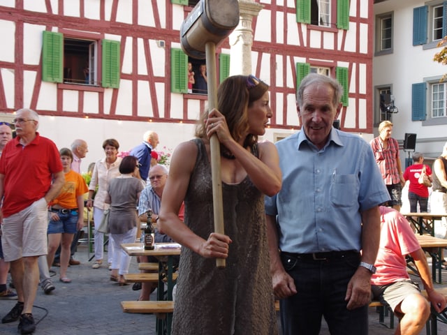 Nicola Spirig hält einen Hammer hoch und lässt sich helfen.
