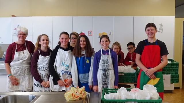 Eine Schulklasse mit Lehrerin lächelt in die Kamera Eine Schulklasse mit Lehrerin lächelt in die Kamera
