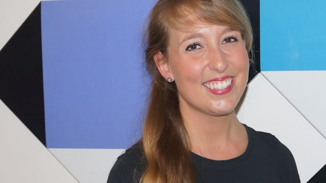 Junge Frau vor farbigen Deko-Tafeln auf weisser Wand im Studio. Junge Frau vor farbigen Deko-Tafeln auf weisser Wand im Studio.