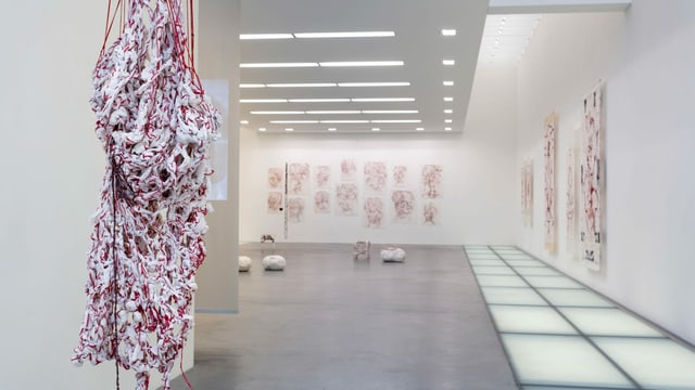 Anischt eines Ausstellungsraum mit einem Kleid aus groben, weissen und roten Fäden. Anischt eines Ausstellungsraum mit einem Kleid aus groben, weissen und roten Fäden.