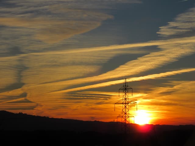 Sonnenuntergang vor einem Hochleitungsmasten