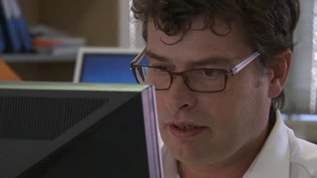 Bergbauexperte Markus Bachmann mit Brille vor Bildschirm sitzend Bergbauexperte Markus Bachmann mit Brille vor Bildschirm sitzend