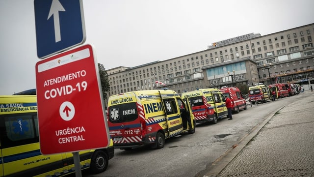 Vor einem Spital warten Krankenwagen in einer langen Reihe. Vor einem Spital warten Krankenwagen in einer langen Reihe.