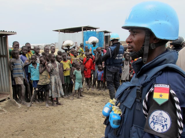 Ein Blauhelmsoldat der UNO und Flüchtlingskinder in einem Dorf im Südsudan. Ein Blauhelmsoldat der UNO und Flüchtlingskinder in einem Dorf im Südsudan.