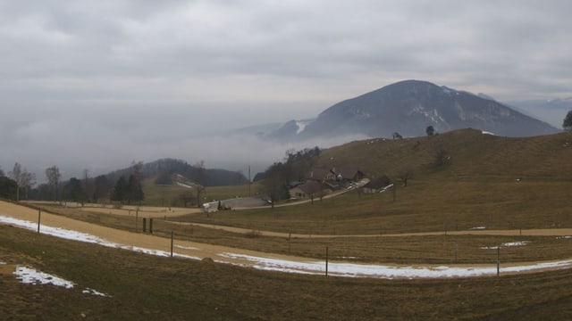 Strasse, die sich den Berg hinauf schlängelt, im Hintergrund Nebelschwaden Strasse, die sich den Berg hinauf schlängelt, im Hintergrund Nebelschwaden