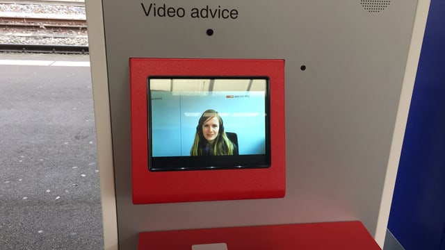 Aus einem Bildschirm am Billettautomat lächelt eine Beraterin entgegen. Aus einem Bildschirm am Billettautomat lächelt eine Beraterin entgegen.
