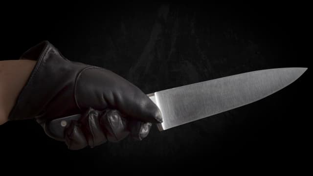 Hand mit Handschuh und Messer Hand mit Handschuh und Messer