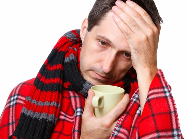 Ein Mann mit Grippe und einer Tasse Tee. Ein Mann mit Grippe und einer Tasse Tee.