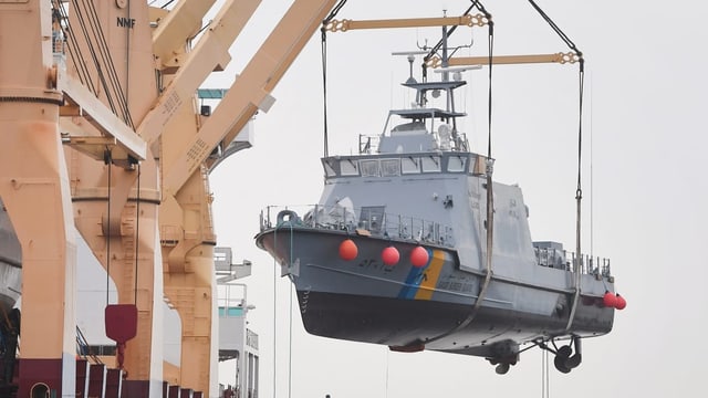 Ein Küstenschutzboot für Saudi-Arabien wird im Hafen von Mukran auf ein Transportschiff verladen (Archiv). Ein Küstenschutzboot für Saudi-Arabien wird im Hafen von Mukran auf ein Transportschiff verladen (Archiv).
