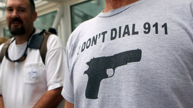 Shirt mit dem Aufdruck "Don't dial 911" und dem Abbild einer Pistole.