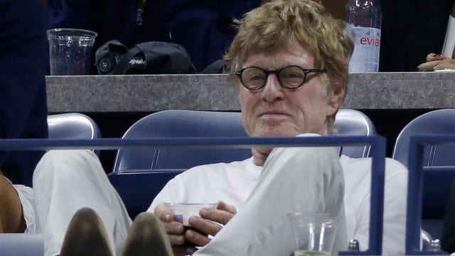 Robert Redford legt die Füsse hoch. Er ist ganz in weiss gekleidet.