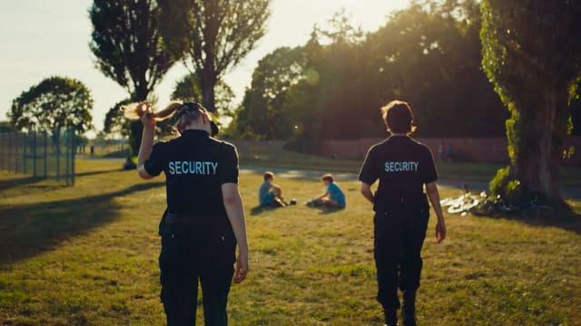 Zwei junge Frauen in Scurity-Uniformen im Park. Zwei junge Frauen in Scurity-Uniformen im Park.