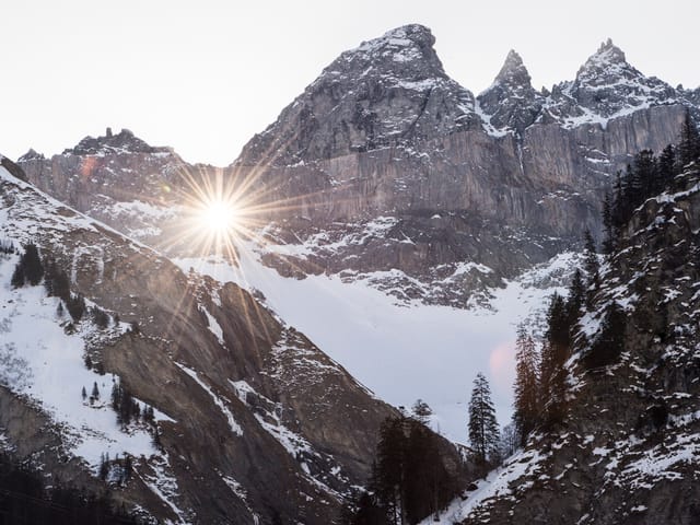 Berggipfel, Sonne scheint hindurch.