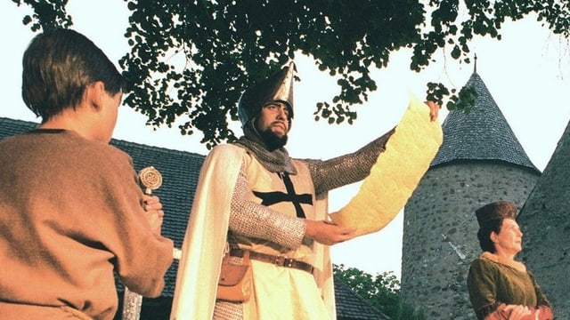 Ein Mann in historischer Kleidung liest aus einer Liste Ein Mann in historischer Kleidung liest aus einer Liste