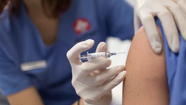 Frau verabreicht Impfdosis