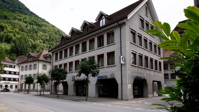 Bankgebäude an einer Strasse im Hintergrund weitere Häuser und Berge. Bankgebäude an einer Strasse im Hintergrund weitere Häuser und Berge.