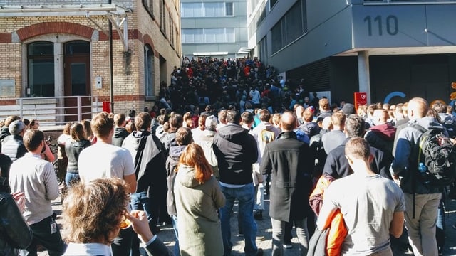 Menschen vor Gebäude Menschen vor Gebäude