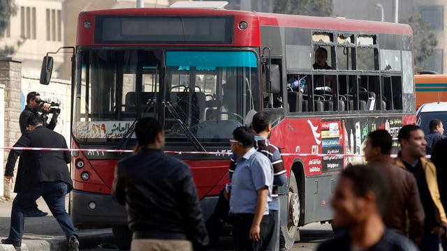Menschen an einem demolierten Bus Menschen an einem demolierten Bus