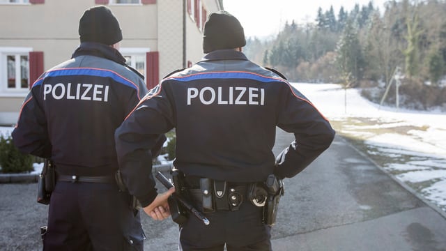 Zwei Polizisten der Luzerner Polizei von hinten betrachtet. Zwei Polizisten der Luzerner Polizei von hinten betrachtet.