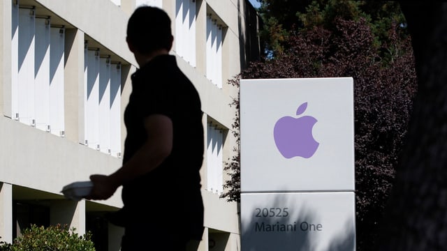 Ein Mann steht vor dem Apple-Gebäude. Ein Mann steht vor dem Apple-Gebäude.