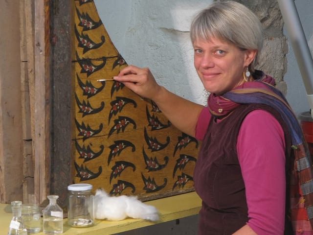 Eine Frau vor einer Wand mit Mustern Eine Frau vor einer Wand mit Mustern