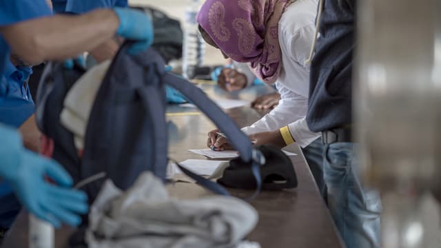 Gepäck von Flüchtlingen wird am Grenzübergang in Chiasso durchsucht. Gepäck von Flüchtlingen wird am Grenzübergang in Chiasso durchsucht.