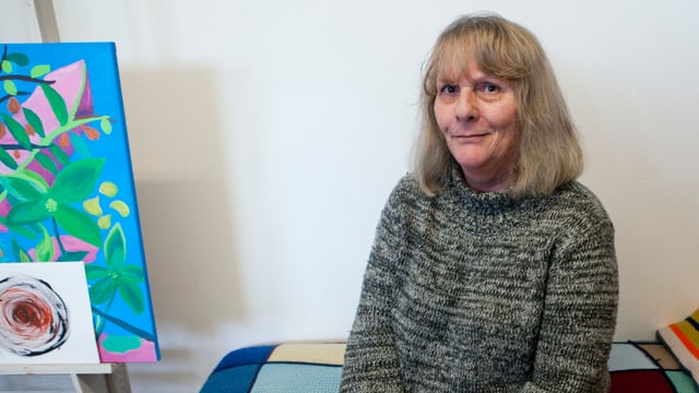 Eine Frau sitzt auf einem Sofa. Eine Frau sitzt auf einem Sofa.