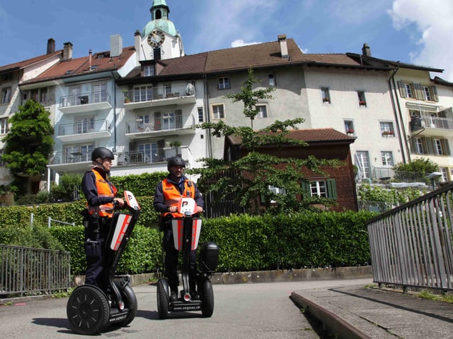 Eine Polizistin und ein Polizist auf Stehrollern. Eine Polizistin und ein Polizist auf Stehrollern.