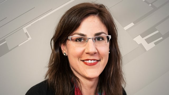 Karin Wenger im Porträt, lächelnd und mit Brille