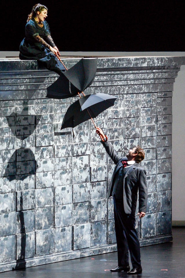 Kathryn Lewek und David Stout mit Regenschirm im Stück «The Merchant of Venice» auf der Bühne. Kathryn Lewek und David Stout mit Regenschirm im Stück «The Merchant of Venice» auf der Bühne.