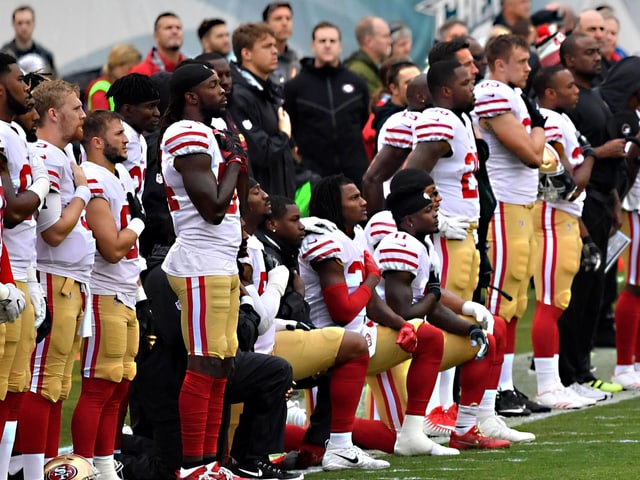 NFL-Profis knien während dem Abspielen der Hymne nieder NFL-Profis knien während dem Abspielen der Hymne nieder