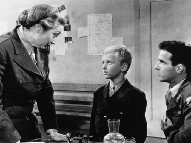 Eine Junge schaut eine Frau in Uniform an. Eine Junge schaut eine Frau in Uniform an.