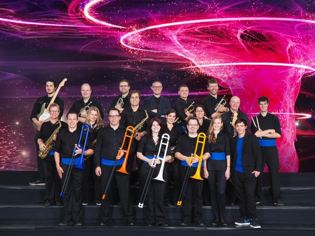 Bigband mit verschiedenen farbigen Posaunen im Gruppenbild Bigband mit verschiedenen farbigen Posaunen im Gruppenbild