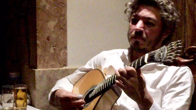 Ein Mann im weissen Hemd spielt Gitarre. Ein Mann im weissen Hemd spielt Gitarre.