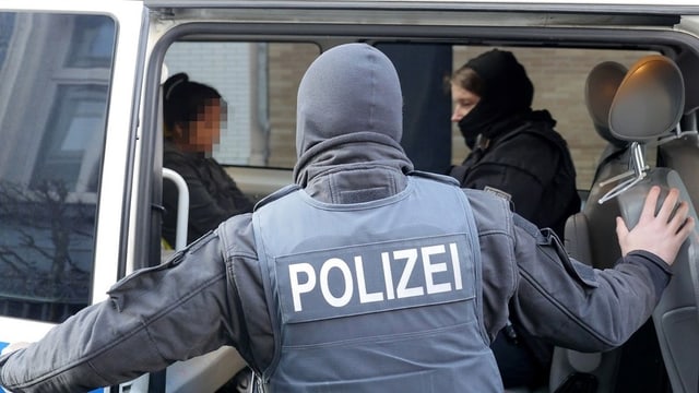 Die Polizei verhaftet eine verdächtige Frau während der grossangelegten Razzien in Deutschland. (keystone) Die Polizei verhaftet eine verdächtige Frau während der grossangelegten Razzien in Deutschland. (keystone)