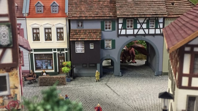Eine Alstadt in Kleinformat. Durch einen Torbogen sieht man die Umrisse eines Drachen. Eine Alstadt in Kleinformat. Durch einen Torbogen sieht man die Umrisse eines Drachen.
