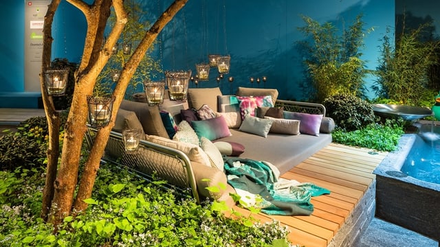 Eine Lounge mit vielen Kissen und Lampen neben einer Wasserwelt Eine Lounge mit vielen Kissen und Lampen neben einer Wasserwelt