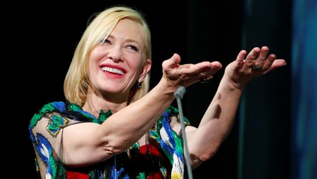 Kate Blanchett strahlt in die Kamera und streckt beide Hände nach vorne. Kate Blanchett strahlt in die Kamera und streckt beide Hände nach vorne.