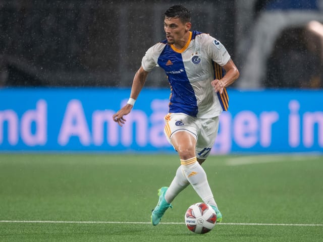 André Ribeiro führt den Ball im Regen. André Ribeiro führt den Ball im Regen.