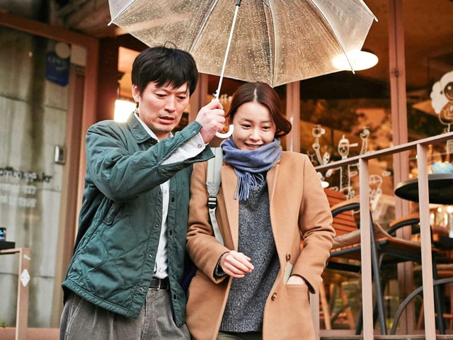 Sunhi und Jae-Hak unter einem Regenschirm. Sunhi und Jae-Hak unter einem Regenschirm.