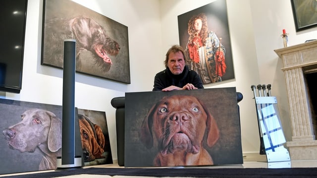ein Mann posiert mit Hundefotografien ein Mann posiert mit Hundefotografien