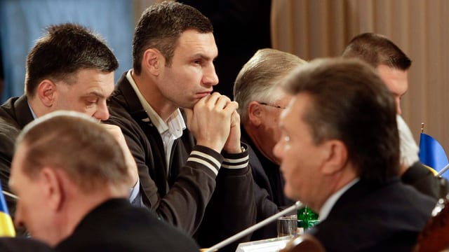 Mehrere nachdenkliche Männer an einem Tisch. In der Mitte scharf gestellt der Oppositionsführer Vitali Klitschko. Mehrere nachdenkliche Männer an einem Tisch. In der Mitte scharf gestellt der Oppositionsführer Vitali Klitschko.