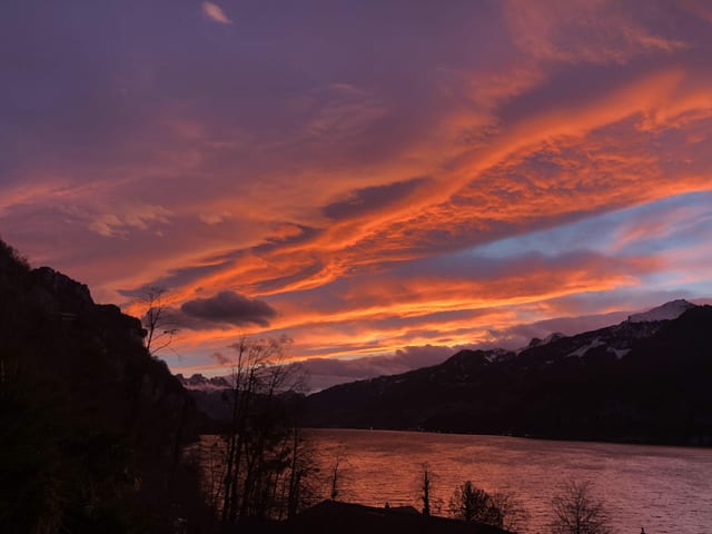 Blick auf den See mit orangem Himmel.