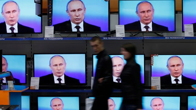 Ein TV-Geschäft mit vielen Bildschirmen im Schaufenster, und Putin auf allen Kanälen. Ein TV-Geschäft mit vielen Bildschirmen im Schaufenster, und Putin auf allen Kanälen.