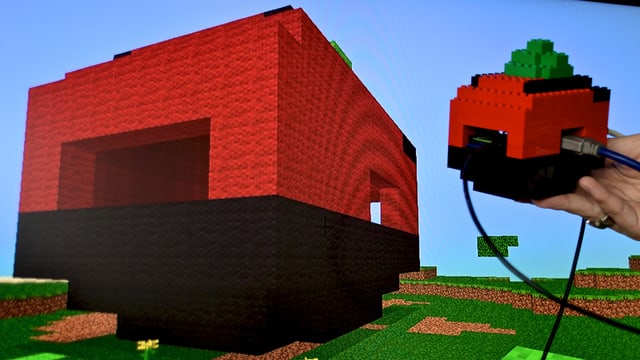 Ein Raspberry Pi vor dem Bildschirm, auf dem wir das Lego-Gehäuse nachgebildet sehen. Ein Raspberry Pi vor dem Bildschirm, auf dem wir das Lego-Gehäuse nachgebildet sehen.