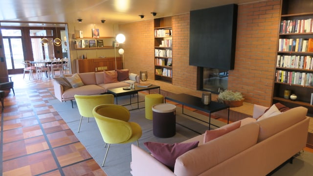 Wohnzimmer mit pastellfarbenen Sitzgruppen, Cheminée und Büchergestellen. Wohnzimmer mit pastellfarbenen Sitzgruppen, Cheminée und Büchergestellen.