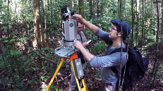 Zwei Männer hantieren mit Laser-Scanner im Wald. Zwei Männer hantieren mit Laser-Scanner im Wald.