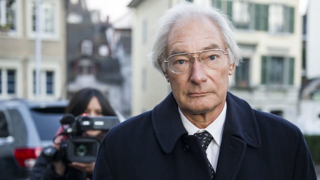 Alter, hagerer Mann. Er schaut ins Bild. Hinter ihm steht eine Frau mit TV-Kamera. Alter, hagerer Mann. Er schaut ins Bild. Hinter ihm steht eine Frau mit TV-Kamera.