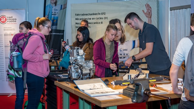 Jugendliche versammeln sich an einem Messestand. Jugendliche versammeln sich an einem Messestand.